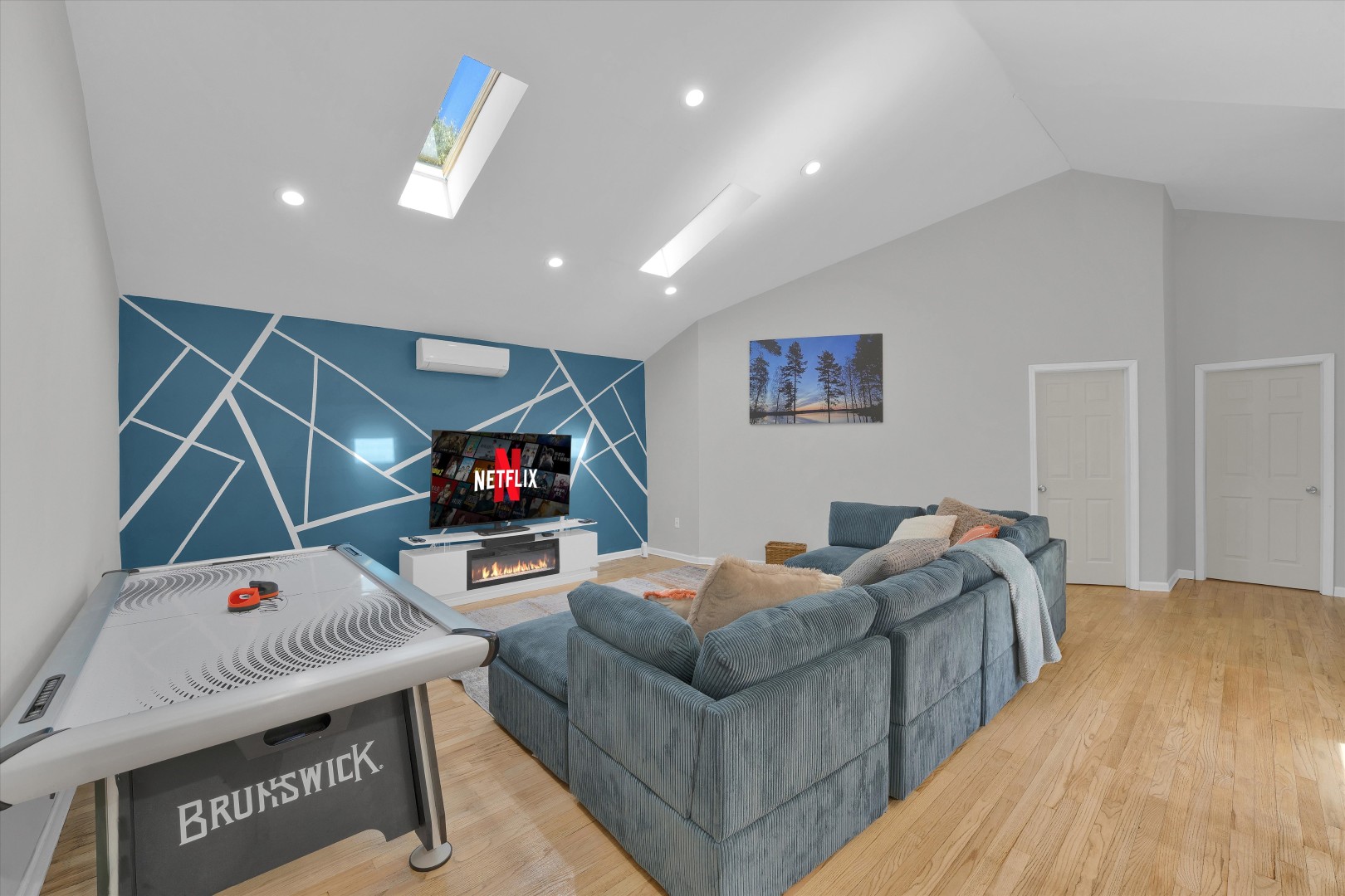 Stream your favorite shows, warm up by the fire, or enjoy a game of air hockey in this bright living area.
