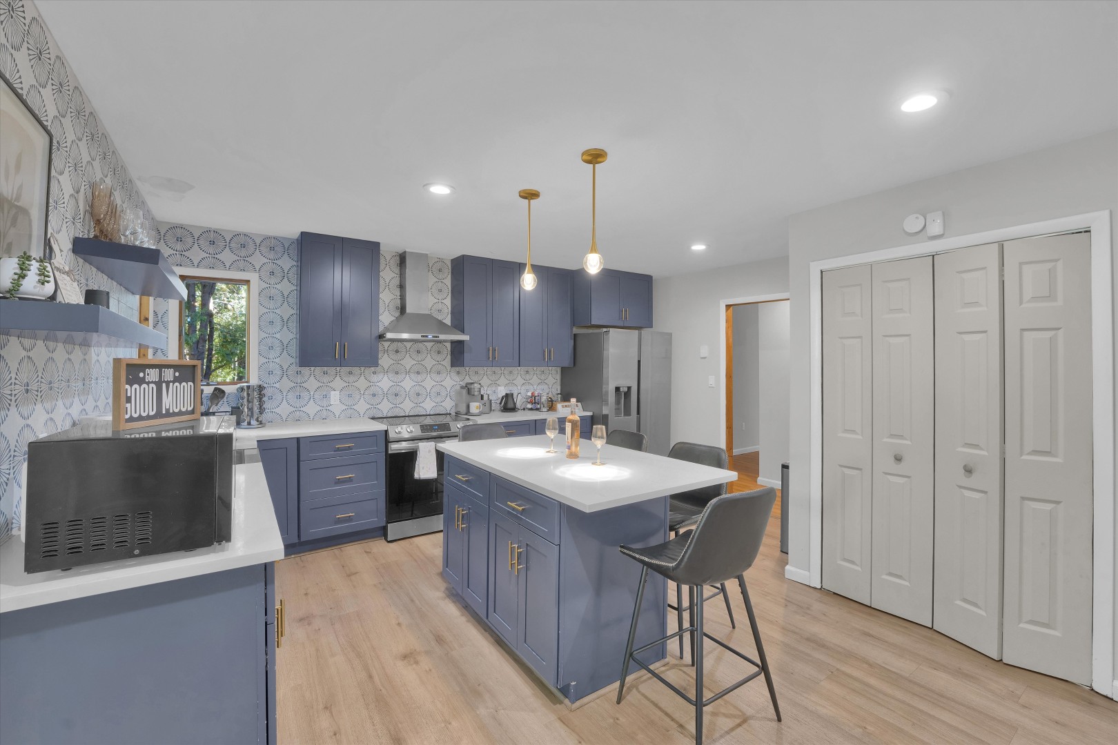 Sleek blue cabinetry meets high-end appliances and a fully stocked coffee bar for effortless group breakfasts.