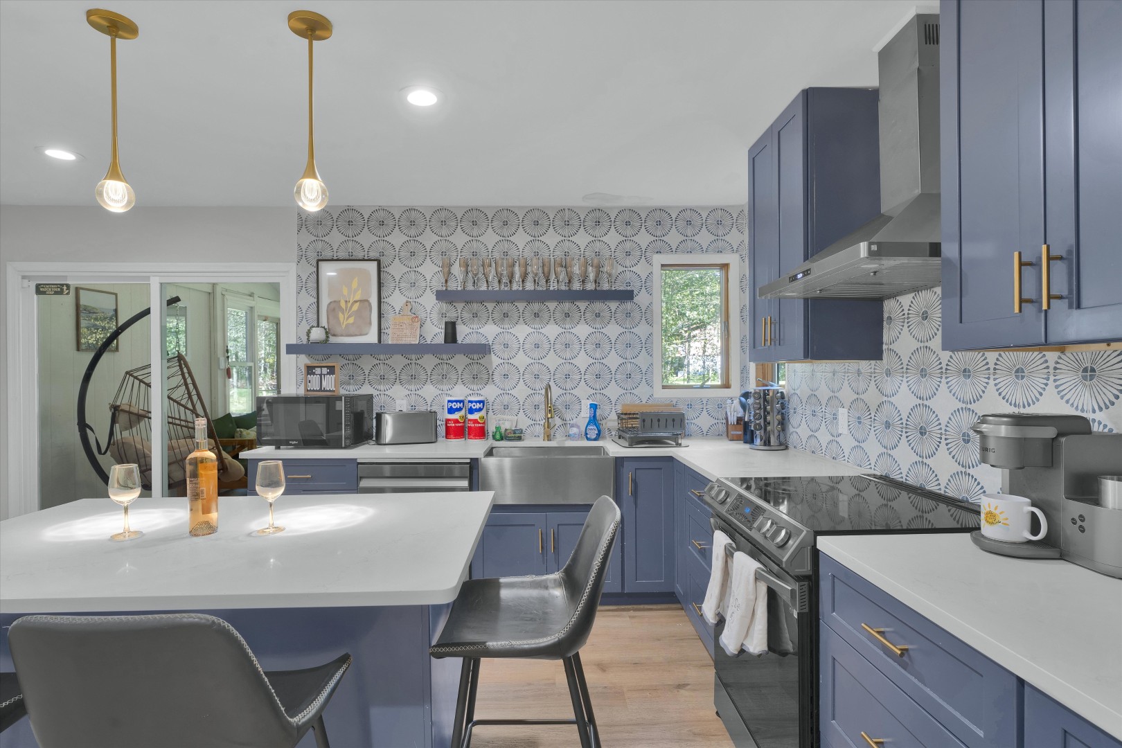 Cook, gather, and socialise in this bright kitchen featuring blue custom cabinets, an island bar, and built-in amenities.