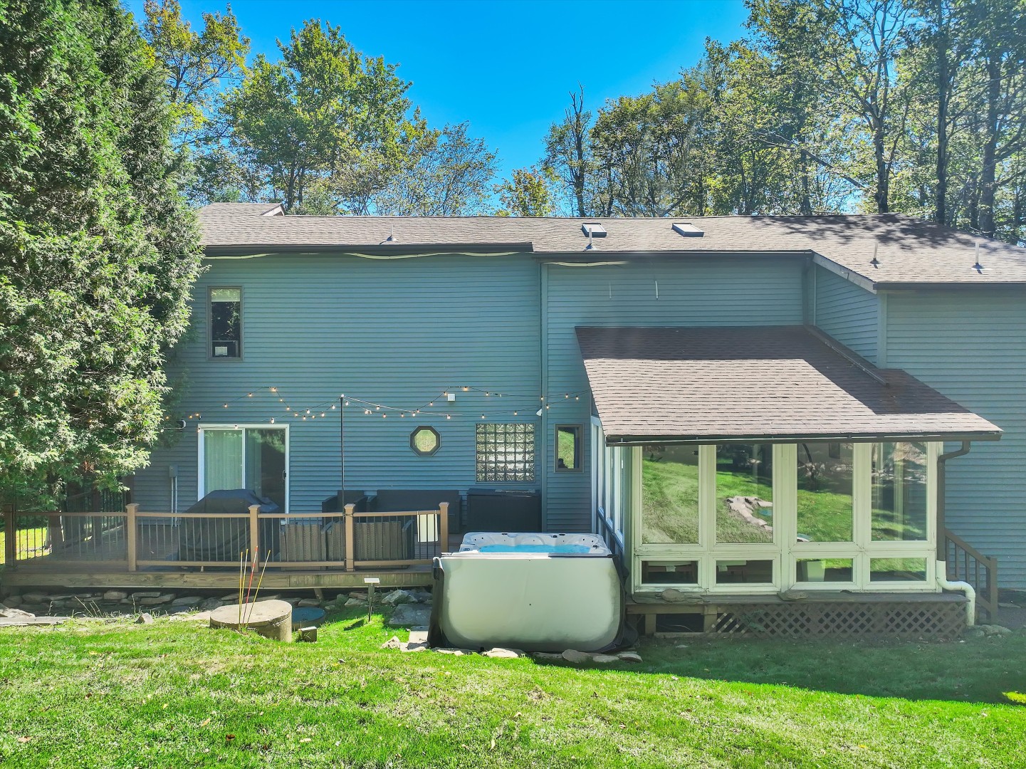Your private outdoor oasis - complete with a hot tub, deck, and four-season sunroom overlooking the woods.