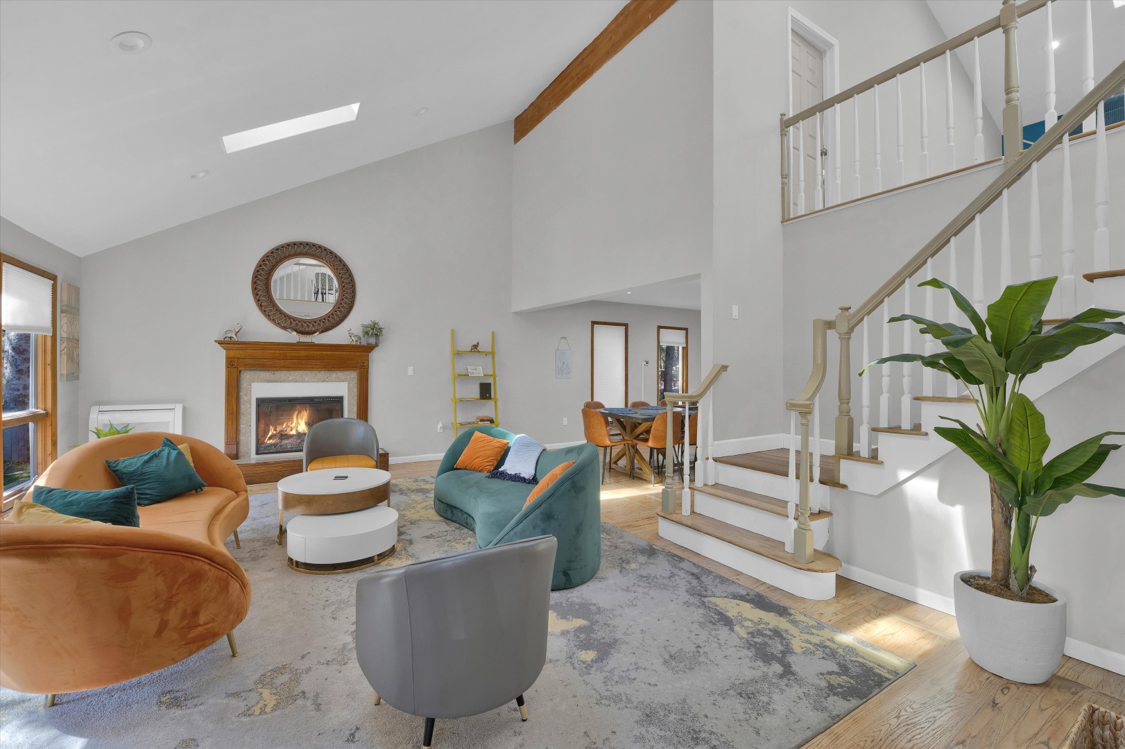 Main floor living room featuring statement curved couches, a cozy fireplace, and grand architectural height.