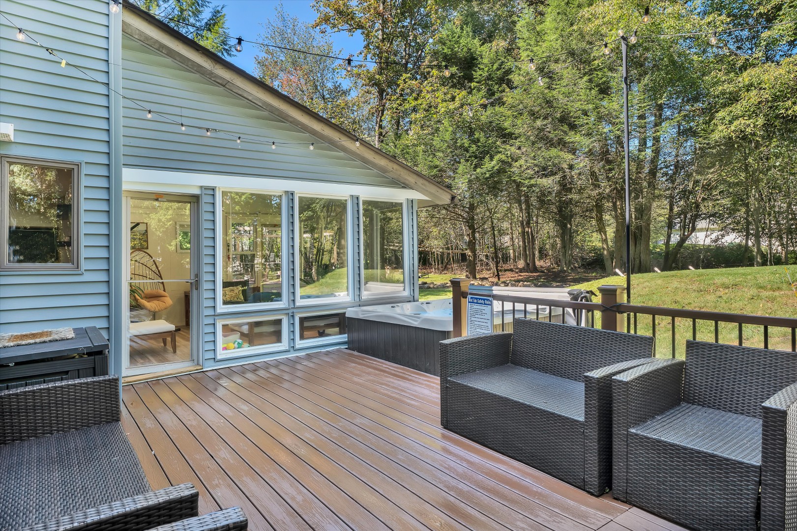 Seamless indoor-outdoor living: glass walls, golden string-light glow, and pure woodland tranquility.