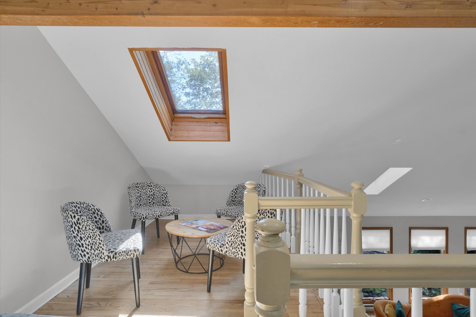 Sunlit loft nook featuring a cozy seating area directly beneath an overhead roof skylight.