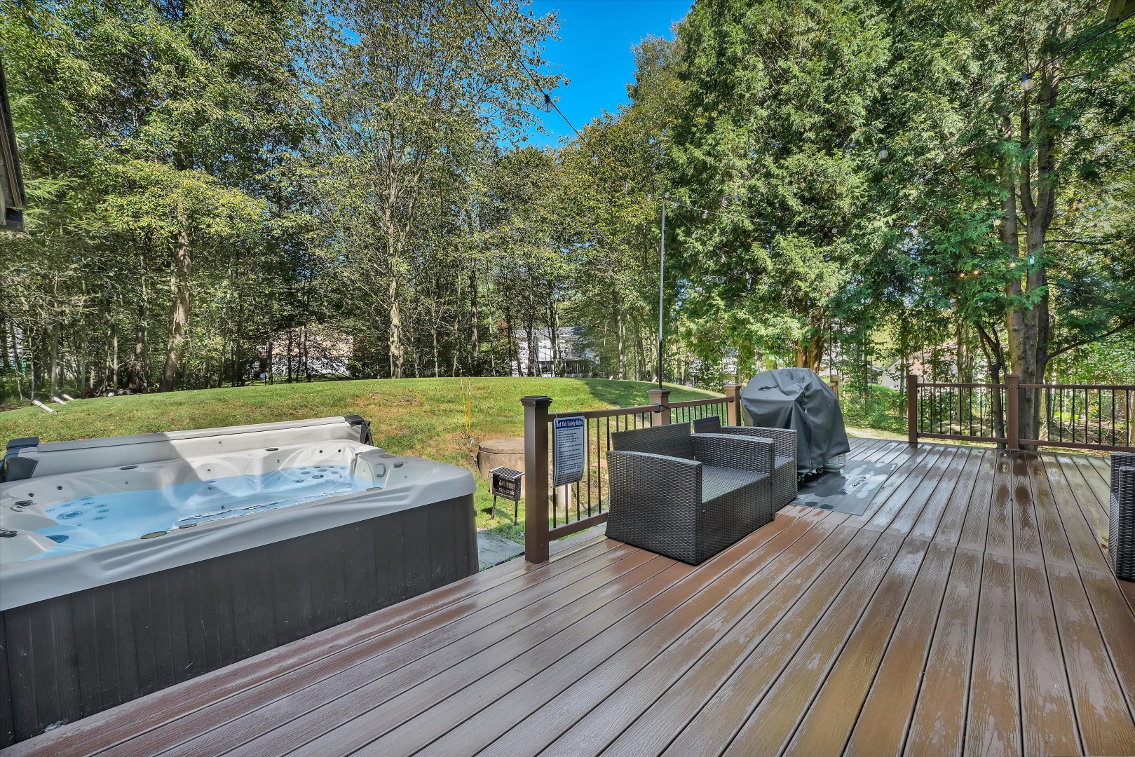 Unwind in the private hot tub while enjoying the peaceful wooded setting from the spacious outdoor deck.