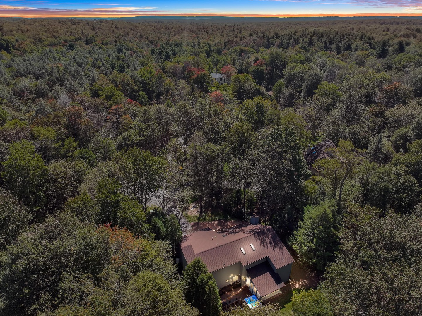 Bird’s-eye view showing the home's private, tree-shrouded location deep in the Poconos woods.