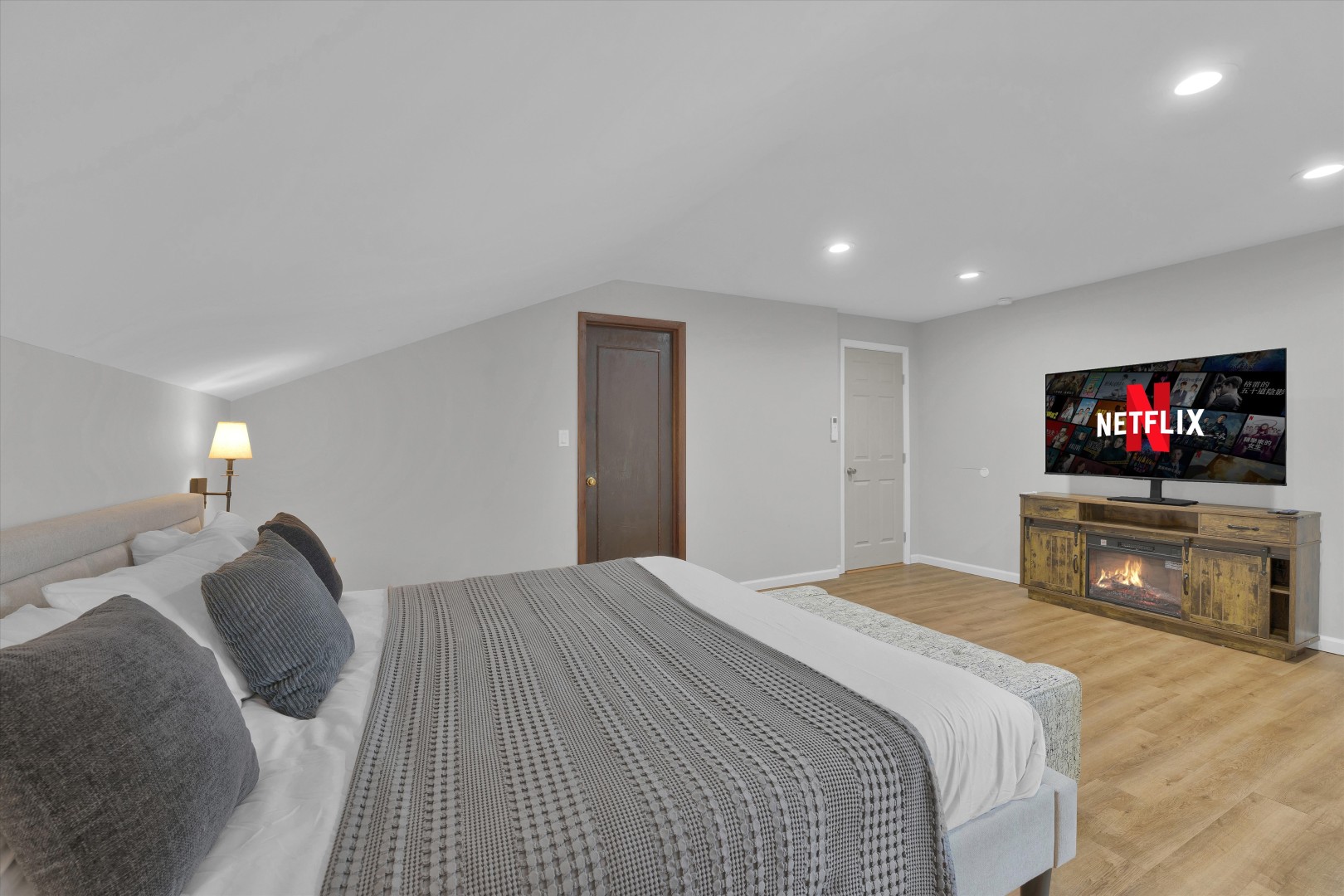 Unwind in bedroom comfort equipped with a wall-mounted Smart TV for late-night streaming.