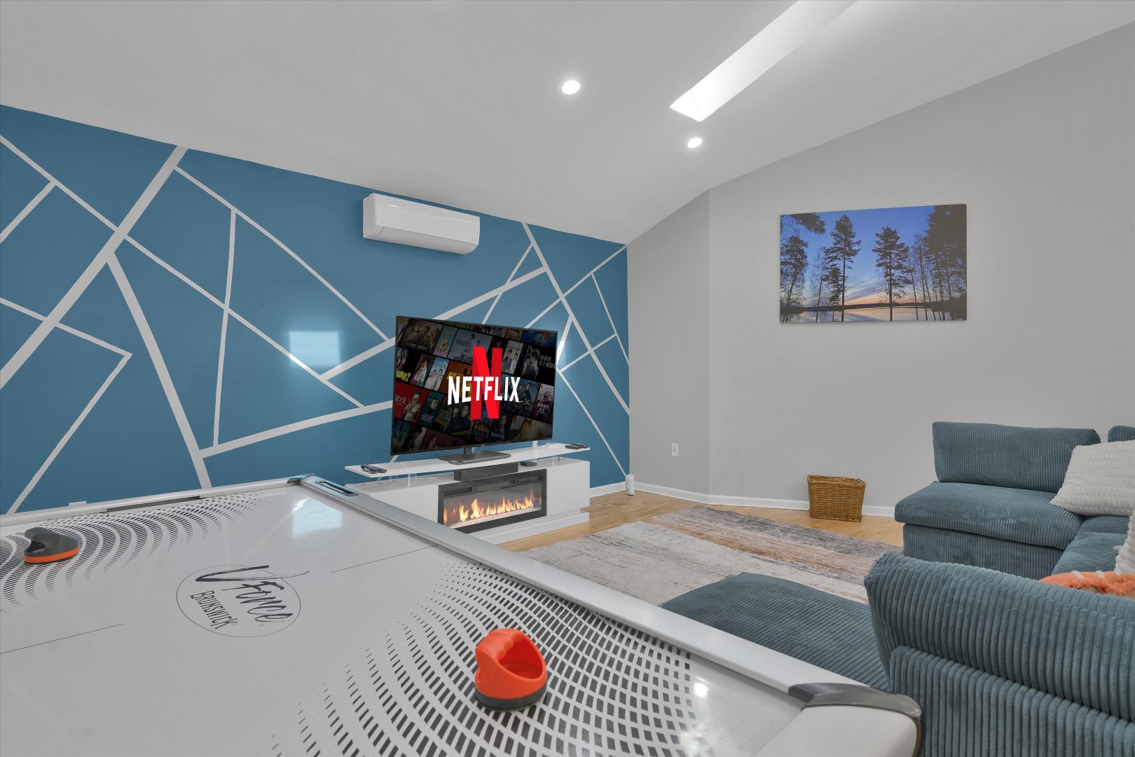 Upper lounge area featuring wood floors, wall TV, and space to relax together.