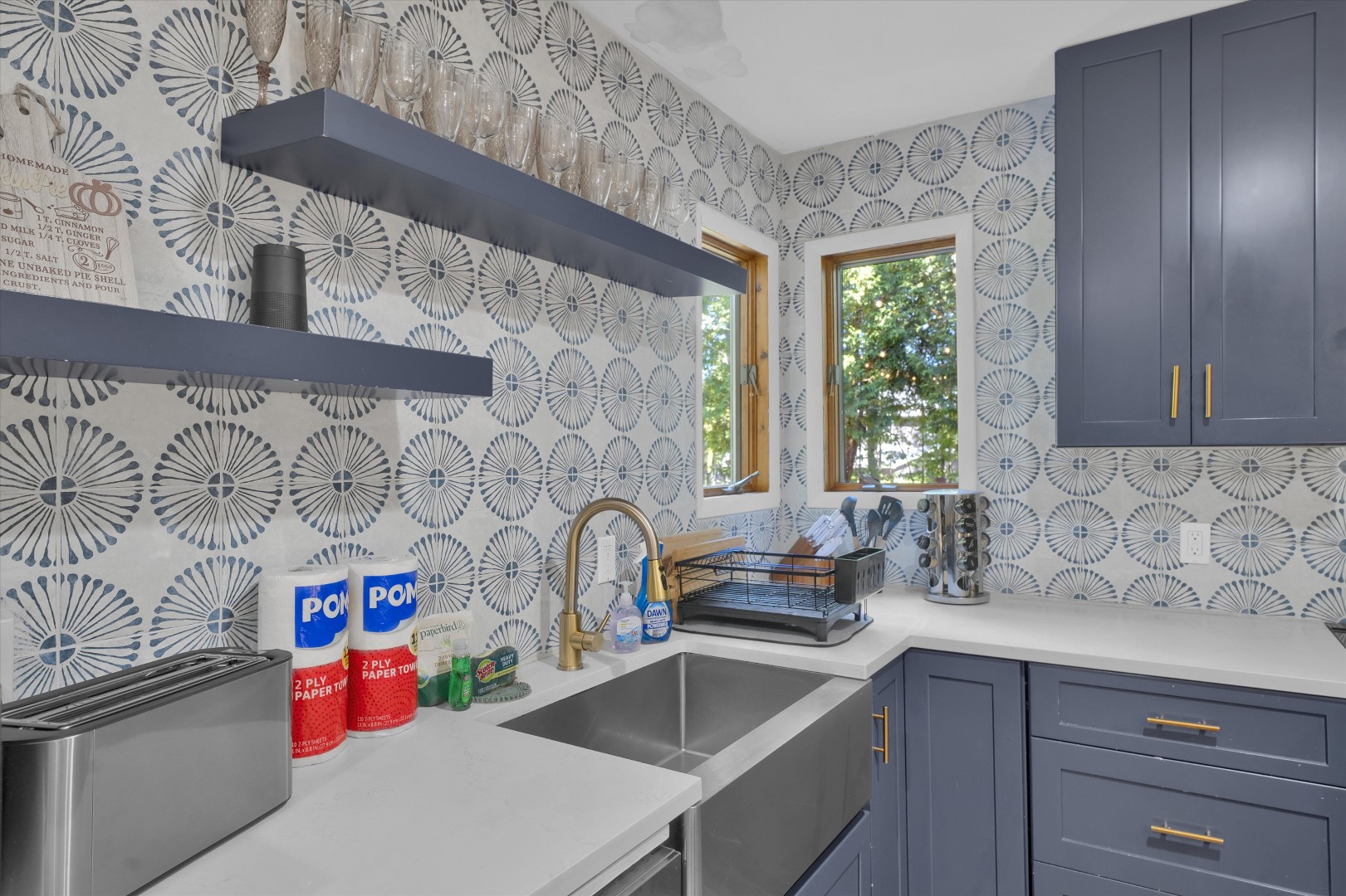 Prep meals with ease featuring a deep undermount sink, brass fixtures, and decorative accent tile.